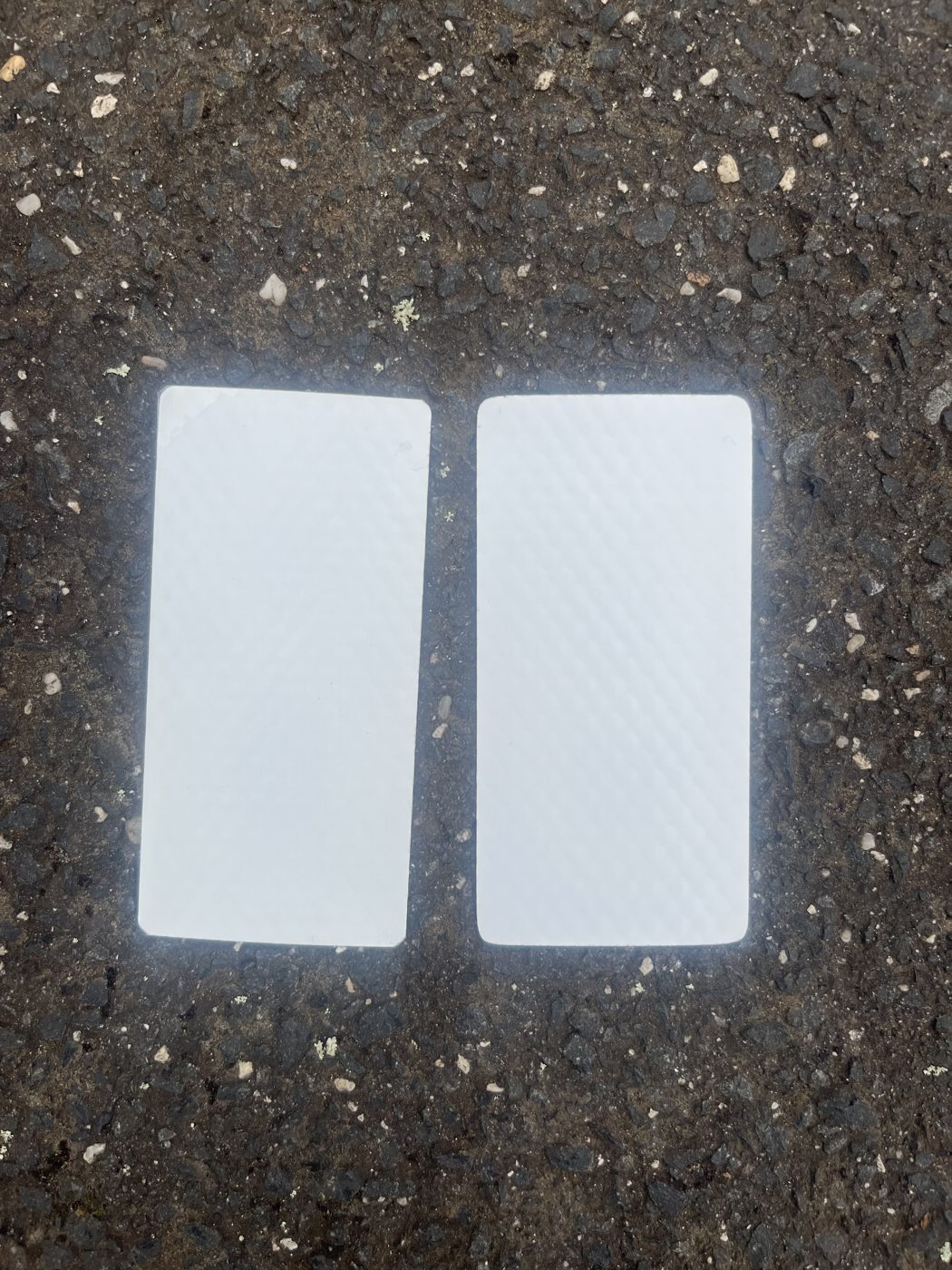 Back of a CurbGlow marker showing the adhesive peel-and-place surface